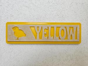 un letrero amarillo con un pájaro amarillo en la pared en COLOR DREAM RESIDENCE Case Vacanza Monopoli, en Monopoli
