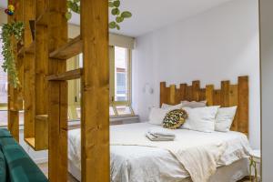 1 dormitorio con 1 cama con marco de madera en Romea Suites en Murcia