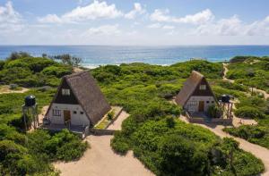 an aerial view of two cottages on the beach at Singila Ocean Lodge in Inhambane