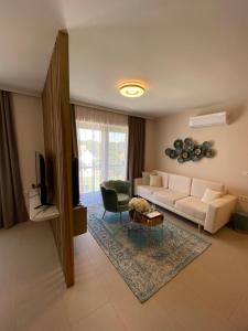 a living room with a white couch and a television at CasaBlanca vendégház in Abádszalók +84 photos