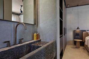 a bathroom with a sink and a mirror at Alaso Design Suites in Fira