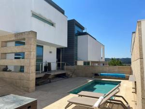 a house with a swimming pool on a patio at Moradia Lux RR com piscina in Penafiel