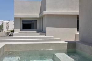 a building with stairs and a pool of water at Alaso Design Suites in Fira