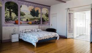een slaapkamer met een bed en een schilderij aan de muur bij Maison des 4 Vallées in La Barthe-de-Neste