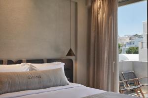una camera da letto con un letto e una grande finestra di Alaso Design Suites a Firà Altre 37 foto