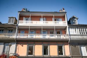 um edifício de apartamentos com uma varanda em cima em Appartement entier Le 1er Balnéothérapie Romantique em Bagnères-de-Bigorre