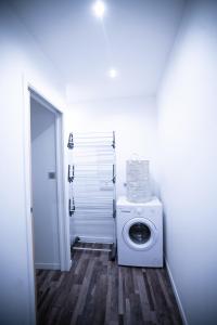 uma lavandaria branca com uma máquina de lavar roupa em Appartement entier Le 1er Balnéothérapie Romantique em Bagnères-de-Bigorre