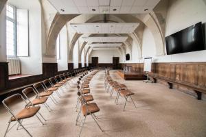 an empty room with chairs and a flat screen tv at HOSTELLERIE CHARLES de FOUCAULD in Viviers