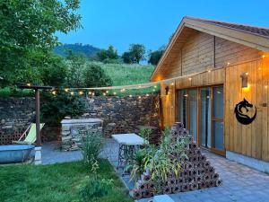 a building with a table and a stone wall at Sárkányok Háza Vendégház - House of Dragons Guesthouse in Raposka