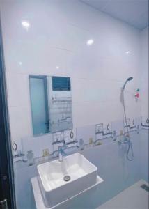 Baño blanco con lavabo y espejo en Hà Linh Motel en Vung Tau