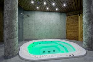 a bath tub in a room with a green pool at Górskie Szczyty Apart & SPA Hawrań Sauna Jacuzzi i Parking w cenie in Zakopane