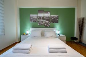 1 dormitorio con cama blanca y pared verde en Awesome, en Atenas