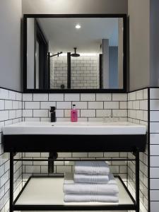 a bathroom with a sink and a mirror and towels at Moxy Belgrade in Belgrade