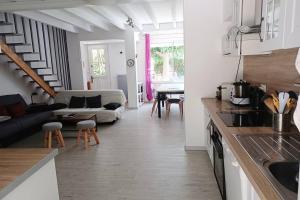 cocina y sala de estar con sofá y mesa en Entre mer et garrigue, en Saint Pierre La Mer