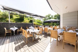 ein Restaurant mit Tischen und Stühlen auf einer Terrasse in der Unterkunft Thermalhotel Leitner in Loipersdorf bei Fürstenfeld