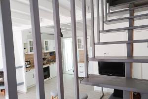 a kitchen with white walls and a staircase in a house at Entre mer et garrigue in Saint Pierre La Mer