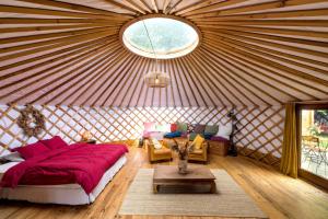 a room with a bed and chairs in a yurt at La Yourte de la Ferme Froidefontaine in Havelange