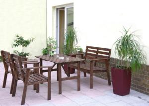 einen Holztisch und zwei Stühle sowie einen Tisch und Bänke in der Unterkunft Apartment Hotel Adler Leipzig in Leipzig