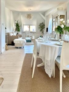een witte eetkamer met een witte tafel en stoelen bij Sopot Apartment 54 in Sopot