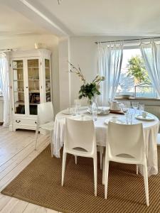 uma sala de jantar branca com uma mesa e cadeiras brancas em Sopot Apartment 54 em Sopot