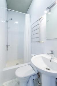 a white bathroom with a toilet and a sink at Апартаменты WOW-hotel in Kyiv