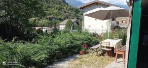 a garden with a table and an umbrella at casa Fiorella in Mattie