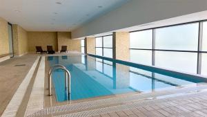 ein großes Schwimmbad in einem großen Gebäude in der Unterkunft Troia Garden View Apartment in Troia