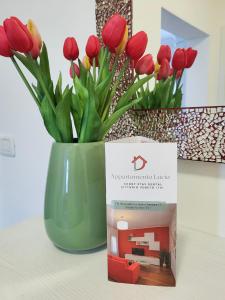 un vase avec des tulipes rouges assis sur une table dans l'établissement Appartamento Lucia, à Vittorio Veneto