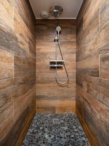 La salle de bains est pourvue de murs en bois et d'une douche. dans l'établissement Montesquieu * Place Stanislas * Idéal Pros, à Nancy