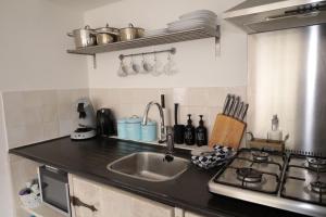 a kitchen counter with a sink and a stove at De Blokhut in Egmond aan den Hoef