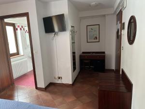 a room with a hallway with a television on the wall at Hotel Alla città di Trieste in Grado