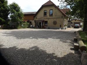 a house with a gravel driveway in front of it at Ferienwohnung Hahnenkrug in Selk
