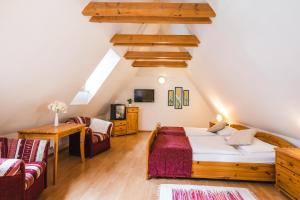 sypialnia na poddaszu z łóżkiem i 2 krzesłami w obiekcie Hotel Zlaty Andel w Czeskim Krumlovie