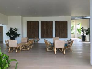 a group of chairs and tables in a room at By The Sea with Side Seaview n Sunset view #3A2 in Batu Ferringhi