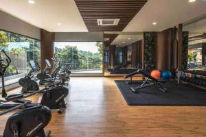 un gimnasio con cintas de correr y bicicletas estáticas en una habitación en To Come Again Abode, IOI Resort City, Putrajaya en Serdang