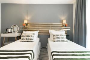 two beds in a room with white walls at Villa Lui Hotel Alaçatı in Ilıca