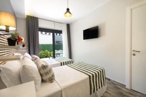 a hotel room with a bed and a window at Villa Lui Hotel Alaçatı in Ilıca