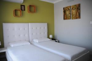 a white bed in a room with a painting on the wall at Hotel Bleu Azur in Argelès-sur-Mer