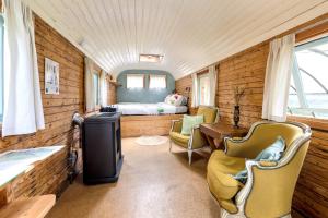 une salle de train avec un lit, un bureau et des chaises dans l'établissement La Roulotte de la Ferme de Froidefontaine, à Havelange