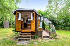 une cabane dans les arbres est présentée dans une cour dans l'établissement La Roulotte de la Ferme de Froidefontaine, à Havelange