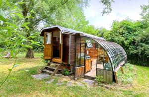 a wooden cabin in the grass in a field at La Roulotte de la Ferme de Froidefontaine in Havelange