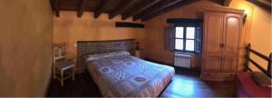 1 dormitorio con 1 cama en una habitación con ventana en Valle de Ur, en Entrambasaguas