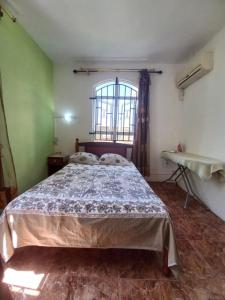ein Schlafzimmer mit einem Bett in einem Zimmer mit einem Fenster in der Unterkunft Coeur de paradis villa in Pereybere
