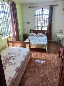 2 Betten in einem Zimmer mit 2 Fenstern in der Unterkunft Coeur de paradis villa in Pereybere
