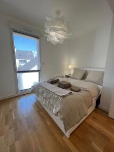 um quarto com uma cama grande e uma janela grande em Appartement vue mer em Carantec