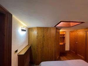 a bedroom with a bed and a wooden cabinet at Due passi dal centro in Col