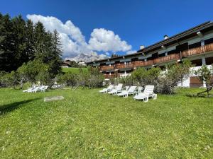 een rij witte stoelen in het gras voor een gebouw bij The best place 300 mt dal centro in Col
