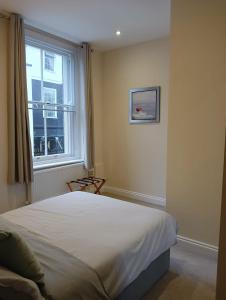 een slaapkamer met een groot bed en een raam bij Barchester House Apartments in Salisbury