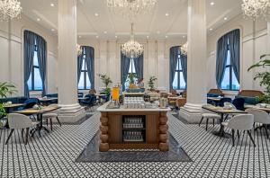 ドンホイにあるRex Quang Binh Hotelのテーブル、椅子、シャンデリアが備わる広い客室です。