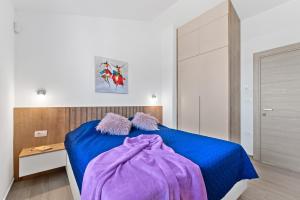 a bedroom with a blue bed with purple blankets on it at Casa Mara in Štokovci +67 photos